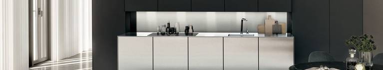 The niche behind this SieMatic stainless steel countertop offers storage space for spices, bottles and cutting boards.